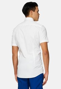 Biela krátkozápästná košeľa so slim fit strihom, s ostrým golierom a jemnými švami. Hladká, ľahká tkanina.