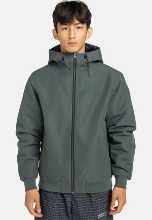 Leichte grüne Jacke mit Kapuze, ausgestattet mit einem Frontreißverschluss, elastischen Bündchen und einem minimalistischen Logo auf der Brust. Glatte Textur.