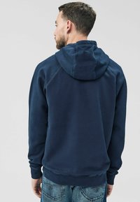 Felpa blu navy realizzata in tessuto morbido, con cappuccio regolabile, polsini e orlo a costine, dal taglio comodo e senza loghi visibili.
