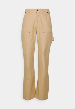 Beige, bomuldsblandede bukser med lige ben, to frontlommer og subtile syninger. Inkluderer en sidelomme til værktøj.