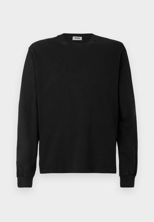 Black long-sleeve crewneck sweatshirt with ribbed cuffs, plain front, and a small visible clothing label inside the collar.