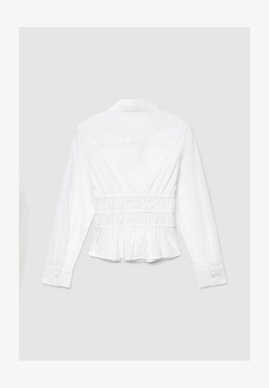 Chemise blanche à manches longues avec taille froncée, col et poignets boutonnés. Ourlet légèrement péplum et texture de tissu en coton lisse.