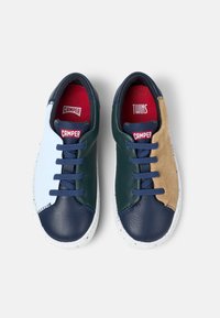 Leather sneakers featuring a multi-colored design in blue, navy, and tan with a textured suede panel, white sole, and contrasting red insoles.