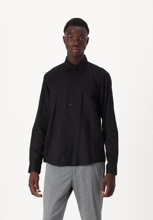 Black button-up shirt with long sleeves, collar, and subtle textured pattern. Made of lightweight fabric, paired with gray trousers.