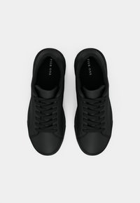 Fekete, alacsony szárú tornacipő pár cipőfűzővel, felülről nézve, fehér háttér előtt. Belső talpán a "Pier One" márkajelzés látható.