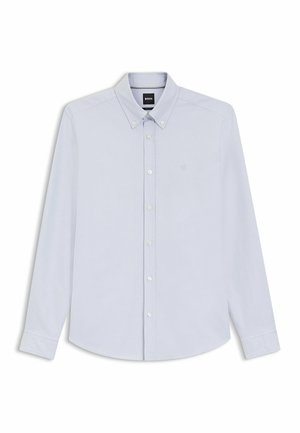Chemise bleu clair à manches longues avec un col boutonné, des boutons blancs et un logo brodé discret sur la poitrine. Texture de tissu lisse.