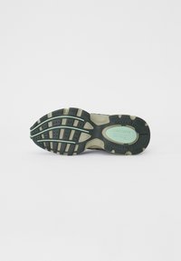 Lacoste athletic shoe sole, featuring a textured black rubber with green accents, sculpted treads, and brand logo in mint green.