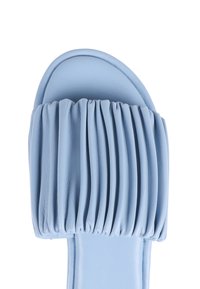 Light blue slide sandal with a padded, pleated upper made of soft material. Smooth sole, rounded toe, and minimalistic design.