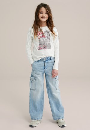 T-shirt blanc à manches longues avec un imprimé graphique rose, associé à un pantalon cargo large bleu clair avec des poches latérales et une coupe décontractée.