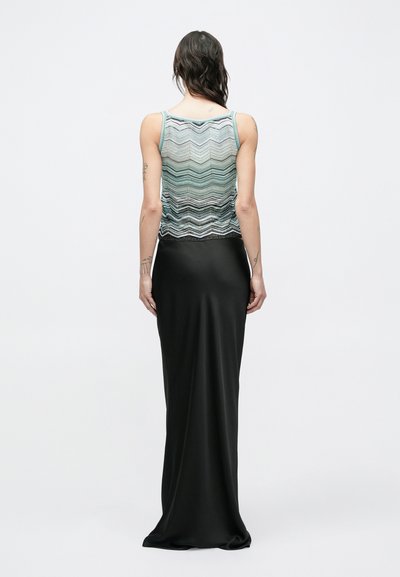 Μαύρο μακρύ φόρεμα από σατέν με εφαρμοστή γραμμή και πολύχρωμη, πλεγμένη μπλούζα με σχέδιο ψαροκόκαλου και λεπτούς ιμάντες.