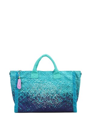 Borsa tote intrecciata turchese e blu navy con manici imbottiti, dettagli con frange e portachiavi viola attaccato a una maniglia.