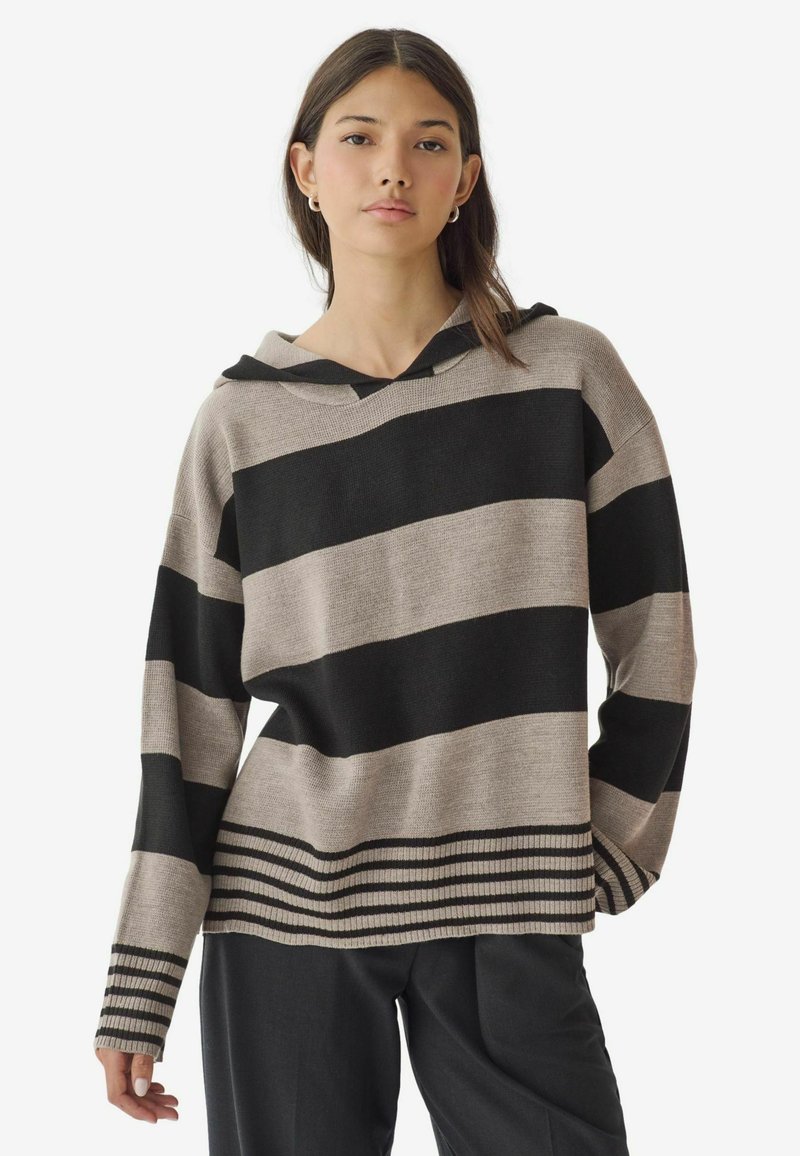 Sweat à capuche rayé en beige et noir, avec de larges rayures horizontales et un bord côtelé en bas de vêtement et aux poignets pour plus de texture.