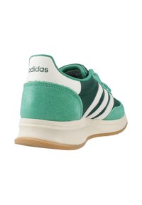 Scarpa sportiva verde e bianca con tallone in camoscio, tomaia in materiale sintetico, tre strisce bianche e suola texturizzata. Logo del brand sul tallone.