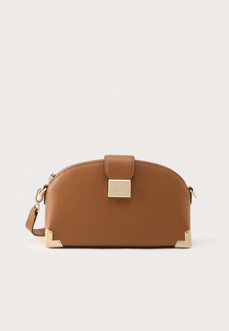 Barna bőrből készült kézitáska ívelt kialakítással, arany színű díszítésekkel, négyzet alakú csattal és megerősített sarkokkal. Állítható pánttal ellátva.