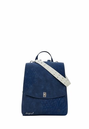 Navy blue backpack with floral embossing, silver clasp, white studded adjustable shoulder strap, and top carry handle.