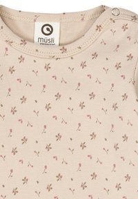 Jasno beżowy bodziak dla niemowląt z kwiatowym wzorem małych różowych kwiatków i zielonych liści. Miękki, elastyczny materiał z zapięciem na zatrzaski.