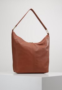 Ruskea nahkainen olkalaukku, jossa on jämäkkä muotoilu, yksinkertainen olkahihna ja vetoketjukiinnitys, sileä pinta ja minimalistinen esteettisyys.