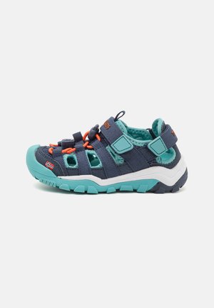 Blue and teal children's shoes with a sturdy rubber sole, textile upper, looped laces, and adjustable straps for a secure fit.
