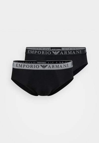 Melni kokvilnas apakšveļas bikses ar pelēku elastīgu jostu, kurā ir "Emporio Armani" logo, un gluda tekstūra, izstādītas pāra veidā.