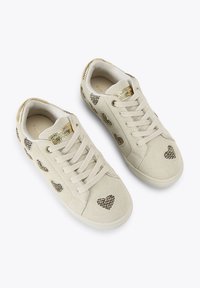 Beżowe zamszowe sneakersy z złotymi akcentami, zdobione wzorami serc z kryształkami, okrągły nos, z zapięciem na sznurówki. Gładka tekstura i wyściełany kołnierz.