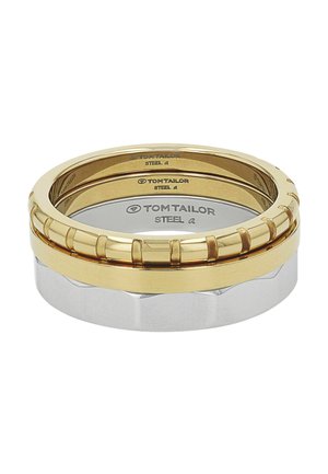 Drei ineinander gestapelte Ringe in Gold- und Silbertönen mit der Gravur "Tom Tailor" auf der Innenseite jedes Rings.