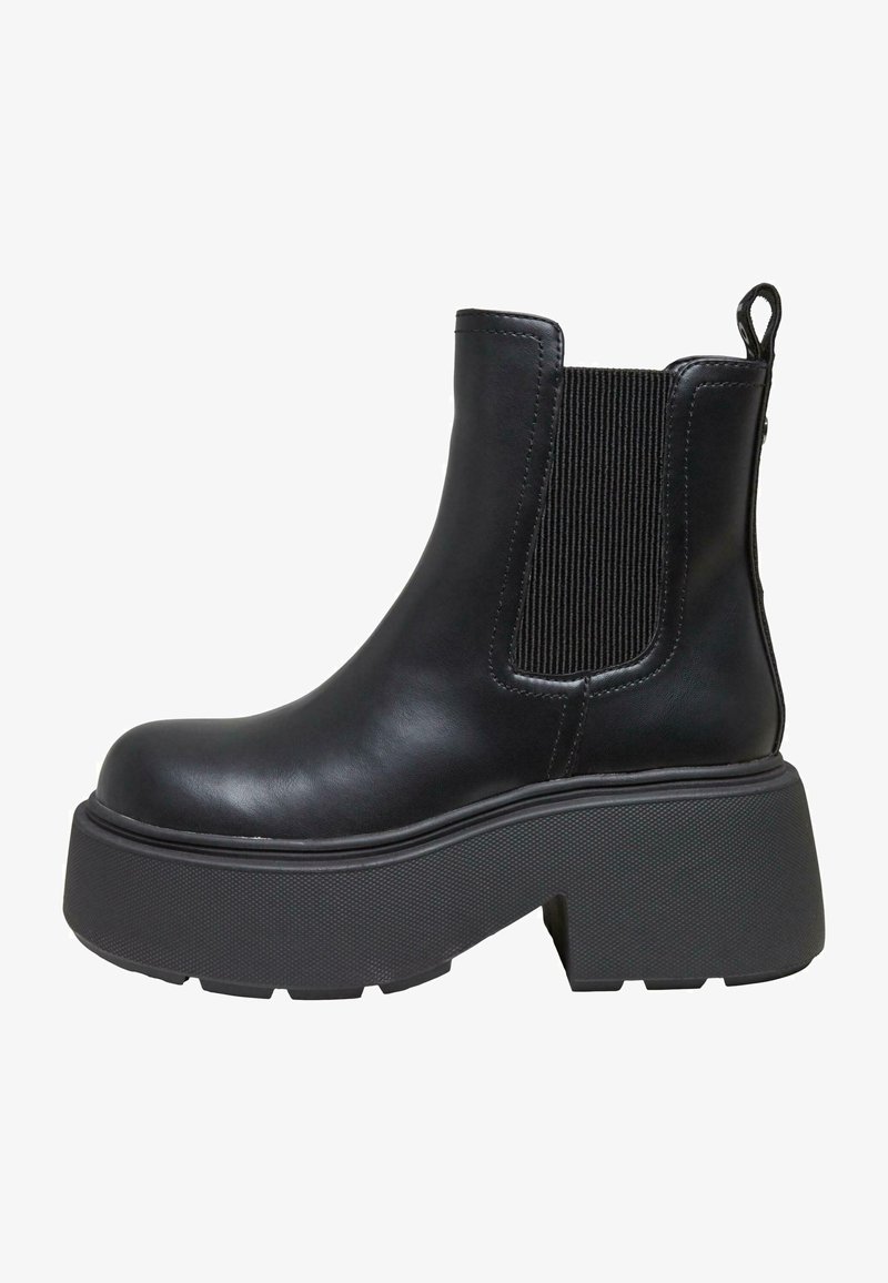 Bottine en cuir noir avec semelle plateforme épaisse, panneau latéral élastique et languette à l’arrière.