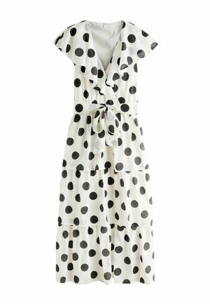 Biele šaty po kolená s veľkými čiernymi bodkami, krátkymi volánovými rukávmi, výstrihom do V, vrstvenou sukňou a opaskom viazaným v páse.