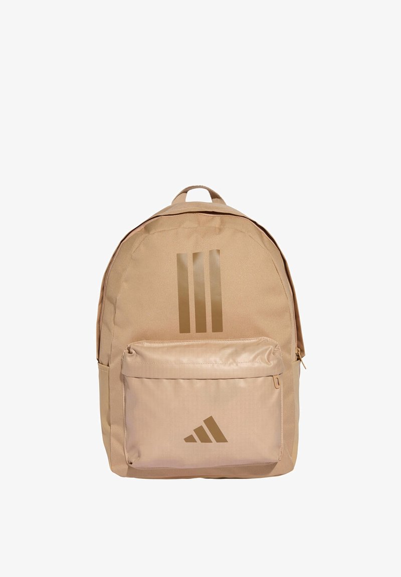 Zaino beige realizzato in tessuto resistente, con un ampio compartimento principale, una tasca frontale con cerniera e il logo Adidas con le tre strisce dorate.