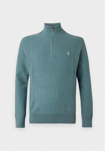 Pull en maille à manches longues couleur sarcelle avec une fermeture éclair d'un quart et un petit logo brodé sur le côté gauche de la poitrine.