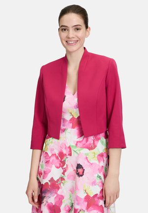 Veste fuchsia courte avec des manches trois-quarts, dotée d'une texture lisse, d'un col structuré et d'un design minimaliste.