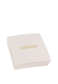 En vit fyrkantig låda med en slät yta, med ordet "amor" i gyllene bokstäver på toppen. Minimalistisk design, utan ytterligare mönster.