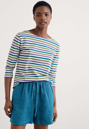 Striped long-sleeve shirt in green, blue, purple, and white; paired with loose aqua shorts featuring an elastic waistband and tie detail.