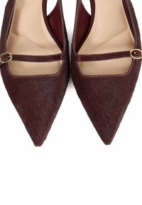 Burgundy pointed-toe flats made from textured hair-on cowhide, featuring a cut-out design and a slim strap adorned with a gold-tone buckle.
