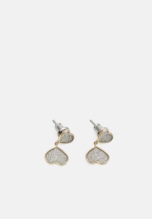 Paire de boucles d'oreilles en forme de cœur avec monture dorée et centre pailleté argenté, chacune avec un petit cœur fixé au-dessus d’un grand cœur suspendu.