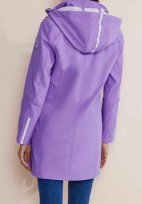 Lila vattentät jacka med huva, långa ärmar, reflexband på axlar och ärmar, samt en mjuk och slät yta.