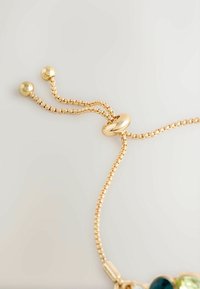 Gold chain adjustable bracelet featuring a polished round bead and two smaller spherical accents, textured links, and smooth surfaces.