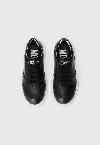 Svarta lädersneakers med vita gummisulor. Funktioner inkluderar rund tå, snörning fram och mönstrad inredning med varumärkeslogotyp.