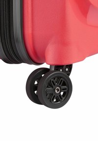 Maleta roja de concha dura con un acabado texturizado, presenta un zipper negro y ruedas giratorias duales de 360 grados para una fácil maniobrabilidad.