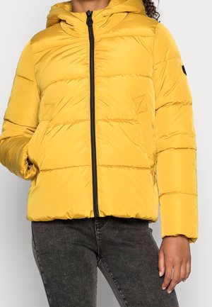 Geel pufferjack met capuchon, voorzien van horizontale stiknaad, een zwarte rits en zijzakken; glad, lichtgewicht materiaal.