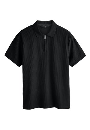 Must valge lühikeste varrukatega polosärk, millel on lukuga krae ja tekstuurse soonikkoe muster lisadetailide jaoks. Sile kangas ja mõnusalt lõdvestunud istuvus.