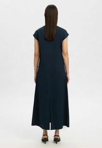 Abito blu navy di lunghezza ginocchio con maniche a cappuccio, taglio dritto e spacco centrale sul retro. Tessuto liscio e design minimalista.