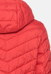 Rød pufferjakke med et chevron-quilt mønster. Har en hætte og en glat, skinnende overflade. Let og isoleret design for varme.