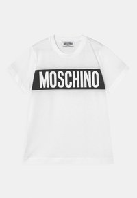 Bílý bavlněný tričko s kulatým výstřihem a krátkými rukávy. Obsahuje výrazný černý pruh přes hrudník s nápisem "Moschino" tučnými bílými písmeny.