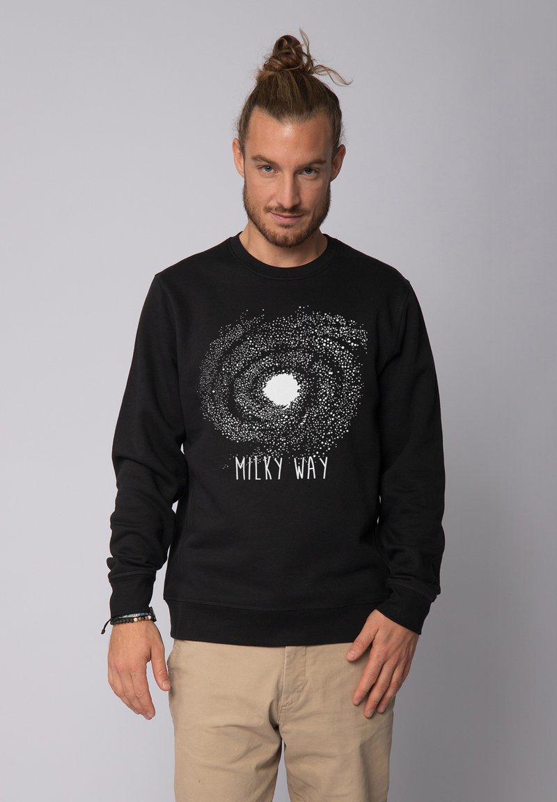 Zwarte sweatshirt met een Melkweg grafiek in het wit, featuring een sterrenachtige spiraalontwerp met een centraal wit gebied en tekst eronder.
