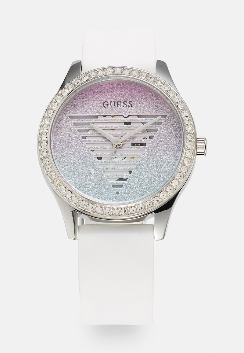 Relógio Round Guess com caixa prateada, pulseira de silicone branca, mostrador em gradiente de rosa a azul com glitter, apresentando recortes em forma de triângulo e detalhes em cristal.
