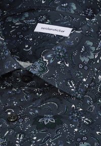 Chemise bleu marine à motif floral avec des boutons noirs et une étiquette "seidensticker" cousue à l'intérieur du col.