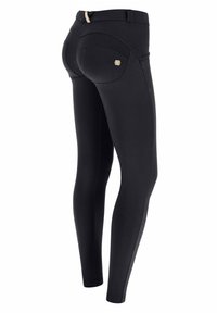 Leggings neri realizzati in tessuto elastico, con vita alta, cuciture curve, tasche posteriori e un piccolo logo in evidenza sul retro.