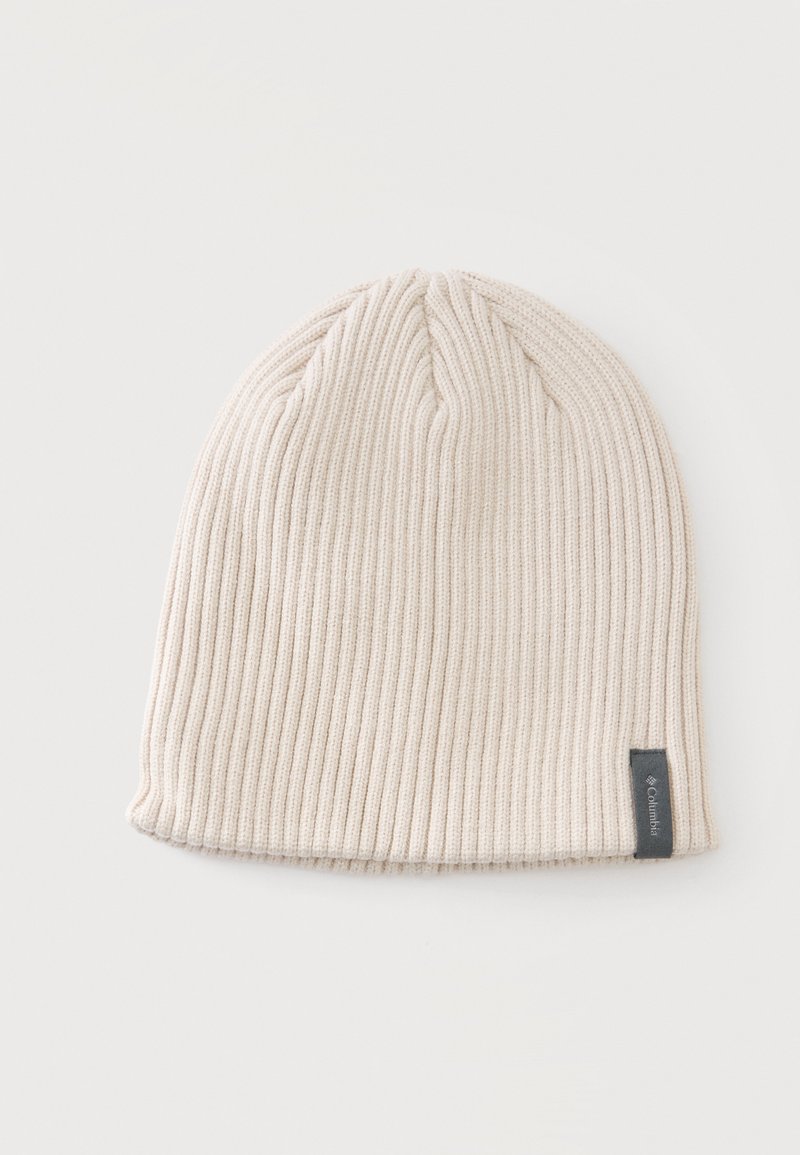 Bonnet beige clair en maille côtelée avec une petite étiquette gris foncé de la marque Columbia en bas.