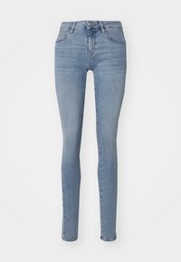 Jeans ajustados en denim azul claro, con una cintura alta, diseño de cinco bolsillos y un ligero desgaste a lo largo de los muslos.