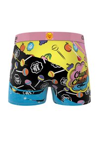Culottes avec une ceinture rose portant le logo "Chupa Chups", des impressions colorées sur le thème des bonbons sur fond noir et jaune, et une accentuation bleue.